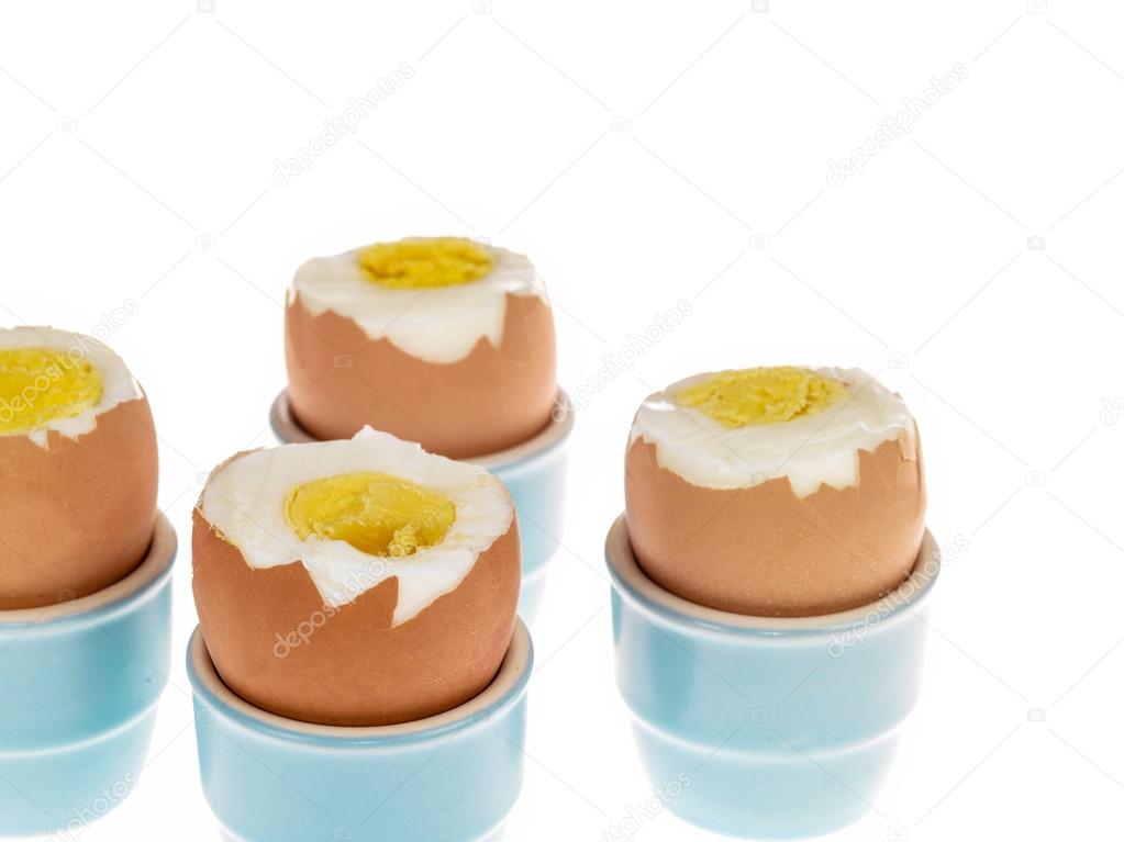 Four Boiled Eggs in Blue China Egg Cups With Their Tops Removed 