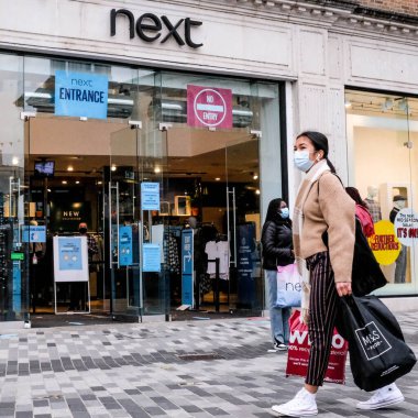 Londra İngiltere 19 Ekim 2020, Bir sonraki High Street Moda Dükkanı önünde, COVID-19 sırasında koruyucu yüz kaplamaları giyen müşteriler
