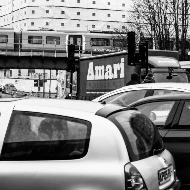 Bir şehir merkezinde demiryolu köprüsünden geçen bir trenle Siyah ve Beyaz Görüntü Ana caddeleri kesişiyor.