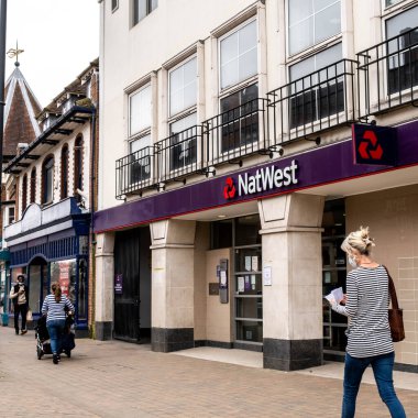 Epsom Surrey London UK, 31 Mart 2021, National Westminster Bank 'ın ana caddesinden geçen kadın.