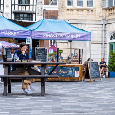 Kingston London UK, 29 Haziran 2021, Dışarıda tek başına oturan genç bir kadın yemek ya da öğle yemeği yiyor.