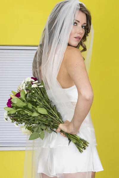 Atractiva joven novia llevando flores — Foto de Stock