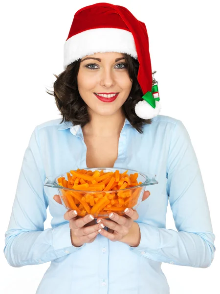 Junge Frau mit Weihnachtsmütze und einer Schüssel Karotten — Stockfoto