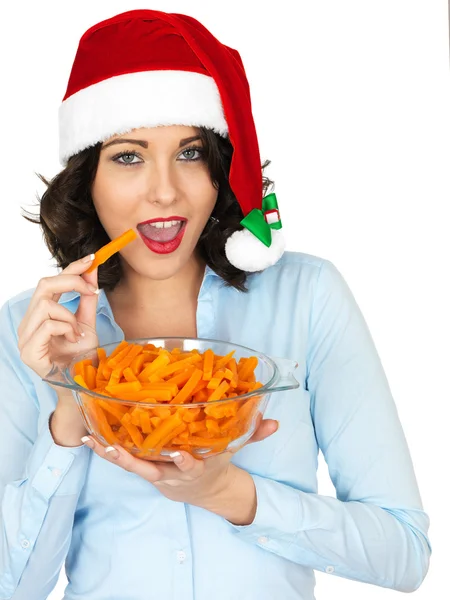 Junge Frau mit Weihnachtsmütze und einer Schüssel Karotten — Stockfoto