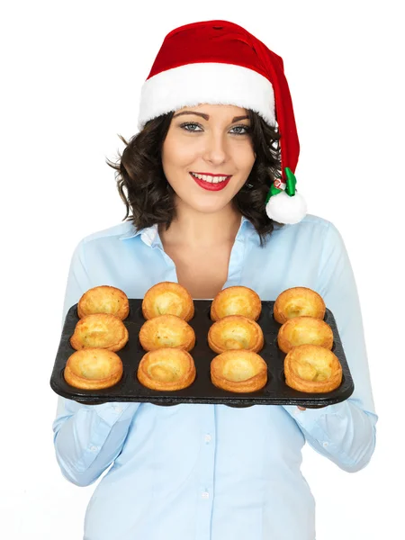 Jonge vrouw in Kerstman hoed bedrijf een lade van Yorkshire pudding — Stockfoto