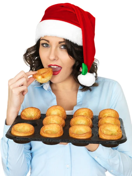 Junge Frau mit Weihnachtsmütze und einem Tablett mit Yorkshire-Puddings — Stockfoto