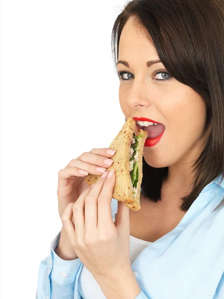 Jeune femme mangeant un sandwich au pain brun — Photo