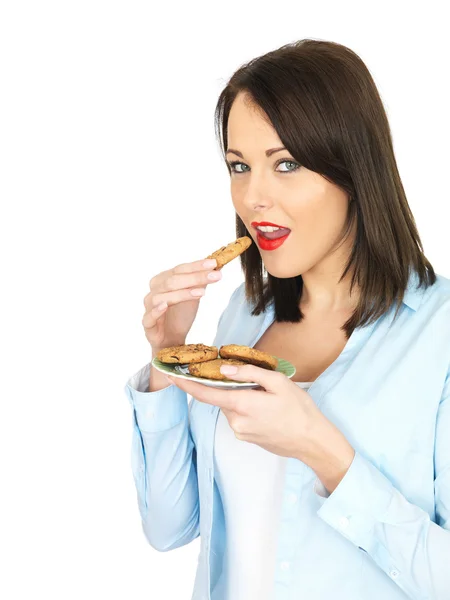 Молодая женщина ест печенье — стоковое фото