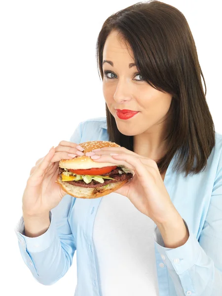 Mujer joven comiendo una hamburguesa de carne — Foto de Stock