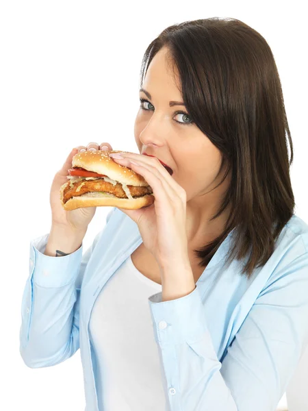 Mujer joven comiendo una hamburguesa de pollo — Foto de Stock