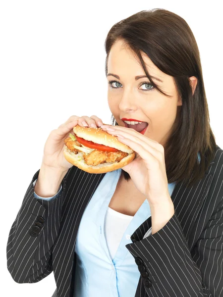 Jovem mulher de negócios comendo um hambúrguer de frango — Fotografia de Stock