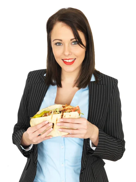 Jovem mulher de negócios comendo um frango Kebab — Fotografia de Stock