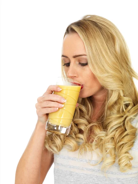 Молода жінка п'є апельсиновий сік — стокове фото