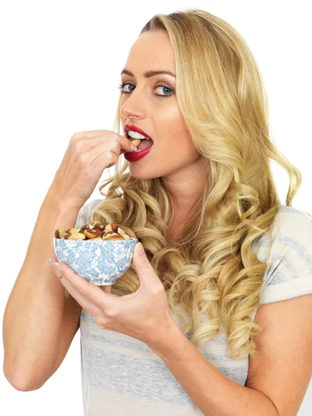 Junge Frau isst eine Schüssel Nüsse — Stockfoto
