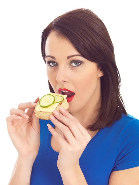 Jovem mulher comendo torrado crrumpet com queijo e pepino — Fotografia de Stock