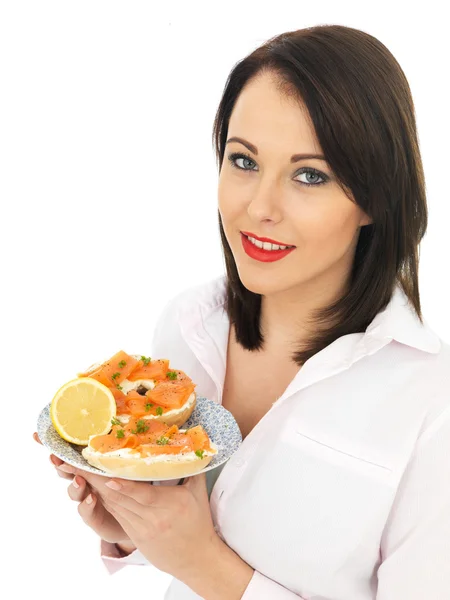 Junge Frau isst geräucherten Lachs und Frischkäse-Bagel — Stockfoto