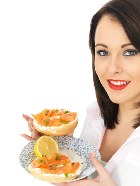 Jovem mulher comendo salmão defumado e creme de queijo Bagel — Fotografia de Stock