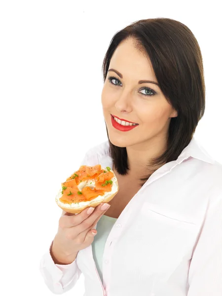 Mladá žena jíst uzený losos a sýrový Bagel — Stock fotografie