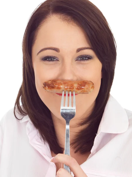 Junge Frau hält eine Wurst auf einer Gabel — Stockfoto