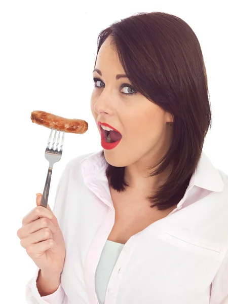 Ung kvinna med en fläskkorv på en gaffel — Stockfoto
