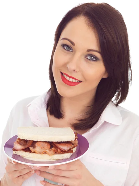 Jovem mulher comer um sanduíche de bacon — Fotografia de Stock