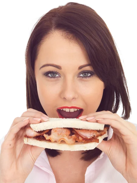 Mujer joven comiendo un sándwich de tocino — Foto de Stock