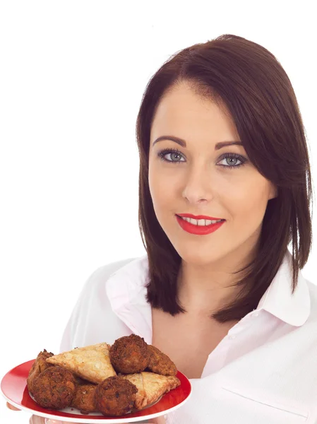 Frau hält einen Teller mit Snacks im indischen Stil — Stockfoto