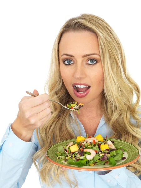 Mujer joven comiendo una ensalada de gambas —  Fotos de Stock