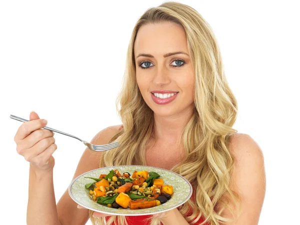 Mujer joven comiendo una ensalada de verduras asadas —  Fotos de Stock