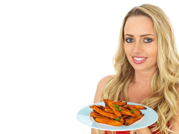 Mujer joven sana sosteniendo un plato de papas dulces — Foto de Stock