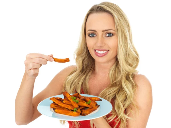 Jeune femme en santé tenant une assiette de patates douces — Photo