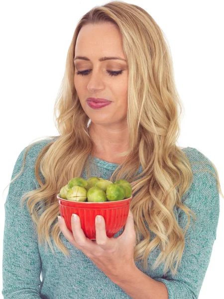 Young Woman Holding a Bowl of Brussels Sprouts — Stock Photo, Image