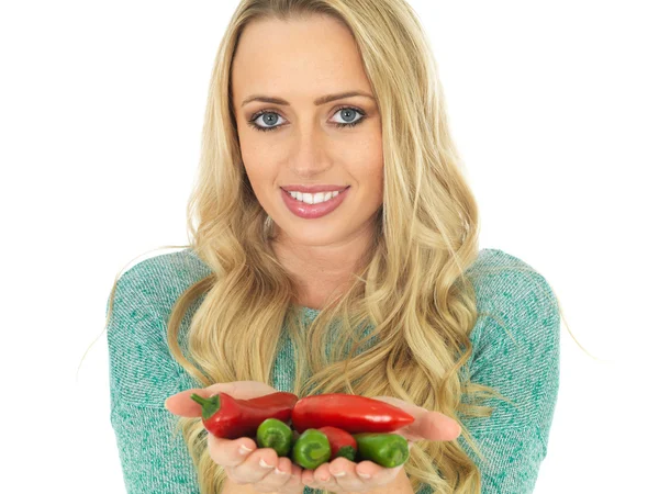 Mujer joven sosteniendo picante picante rojo y verde chiles — Foto de Stock