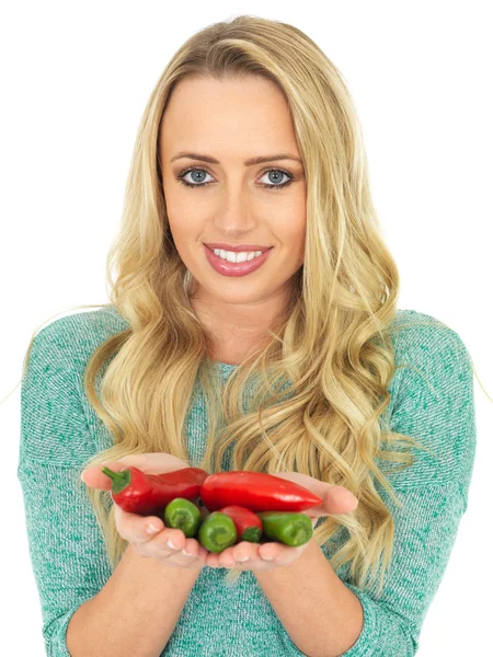 Mladá žena držící horké pikantní červené a zelené papriky — Stock fotografie