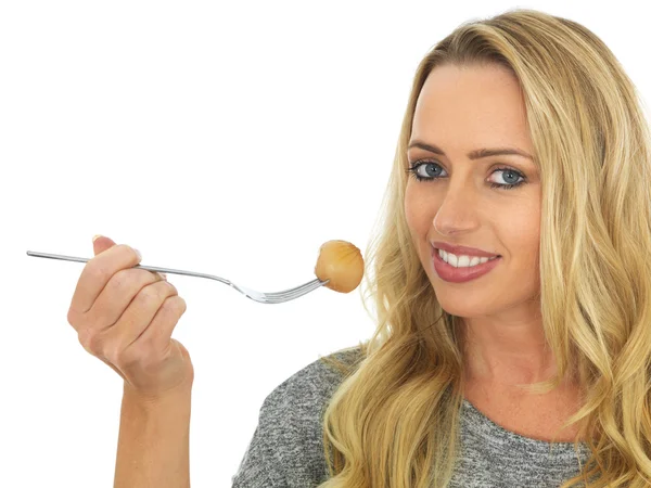 Mujer joven sosteniendo una cebolla en escabeche en un tenedor — Foto de Stock