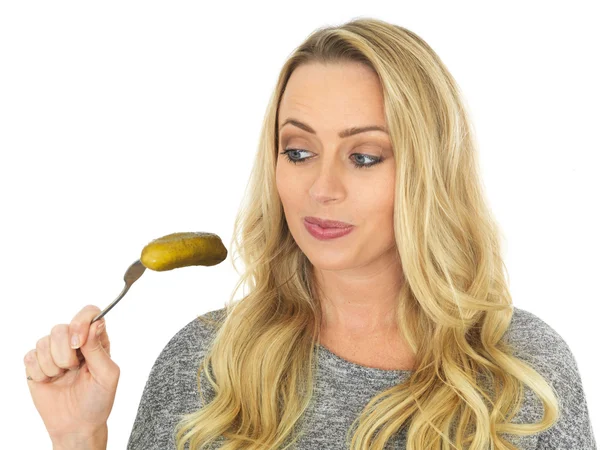 Joven mujer sosteniendo un gherkin en un tenedor — Foto de Stock