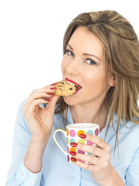 Νεαρή γυναίκα που απολαμβάνει τσάι και μπισκότα — Φωτογραφία Αρχείου