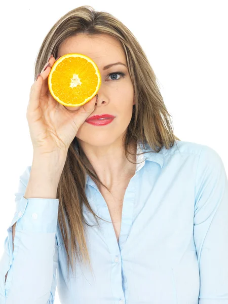 Mujer joven sosteniendo una naranja — Foto de Stock