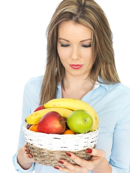 Mujer joven sosteniendo una cesta de fruta —  Fotos de Stock