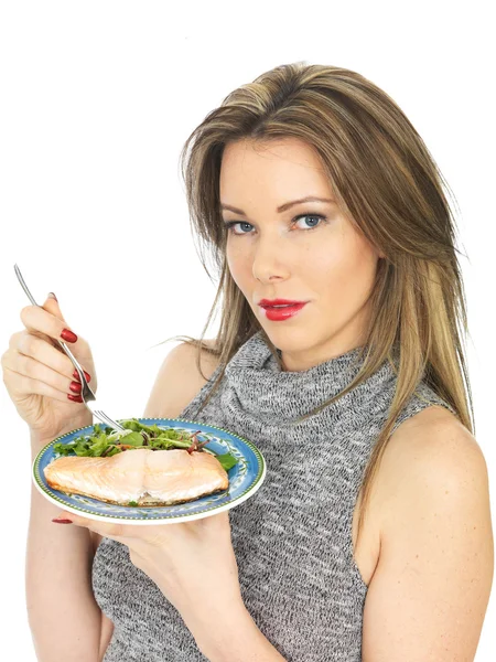 Mujer joven comiendo Slamon escalfado y ensalada —  Fotos de Stock