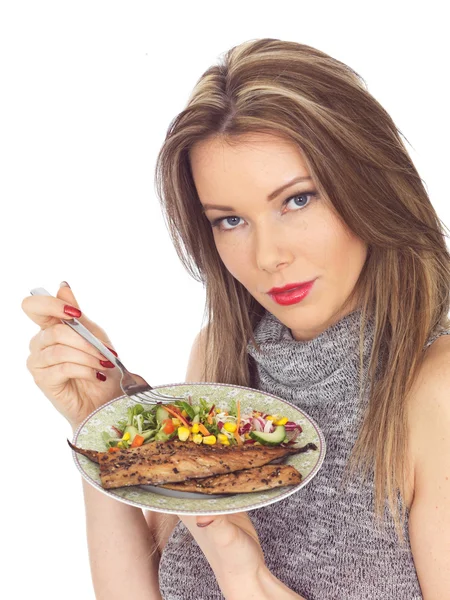 Mujer joven comiendo caballa y ensalada — Foto de Stock