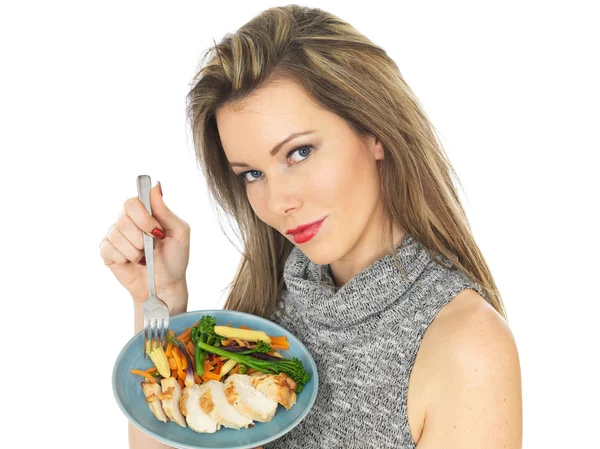 Mujer joven comiendo pechuga de pollo con verduras — Foto de Stock