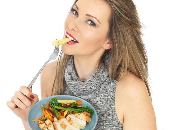 Jeune femme manger poitrine de poulet avec des légumes — Photo