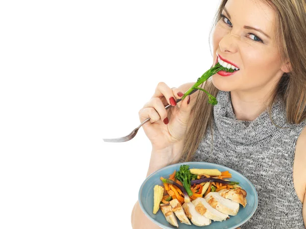 Jeune femme manger poitrine de poulet avec des légumes — Photo