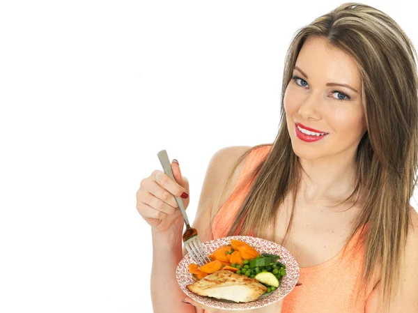 Jovem mulher comer frango grelhado com legumes — Fotografia de Stock