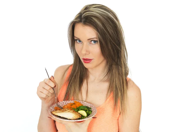 Genç kadın sebzeli ızgara tavuk yemek — Stok fotoğraf
