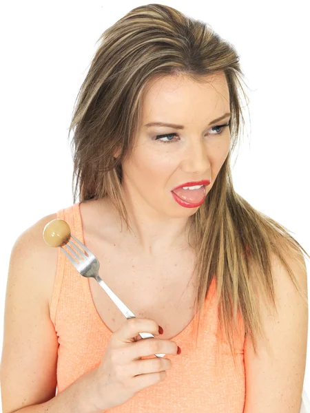 Giovane donna che tiene una cipolla sottaceto su una forchetta — Foto Stock