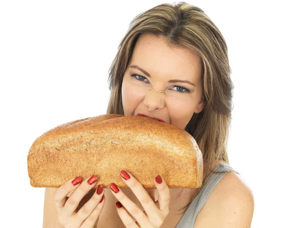 Giovane donna che tiene una pagnotta di pane marrone — Foto Stock