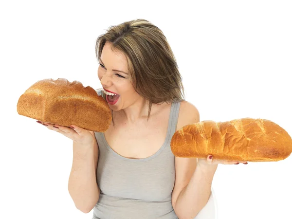 年轻女人比较白色和棕色面包 — 图库照片