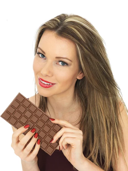 Giovane donna che tiene una tavoletta di cioccolato al latte — Foto Stock